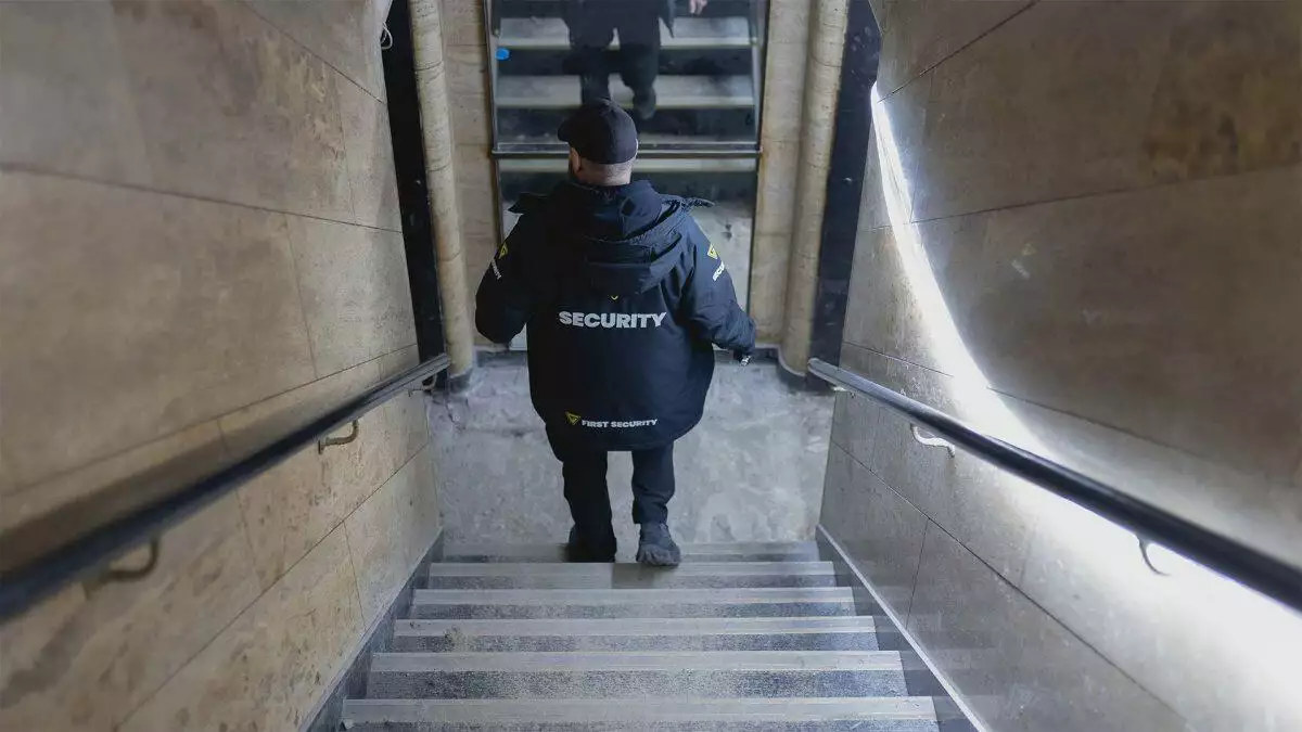 En vagt i uniform går ned ad en trappe.