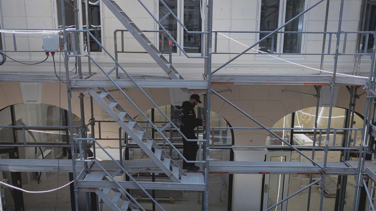 En vagt i uniform på stilladser i en bygning.